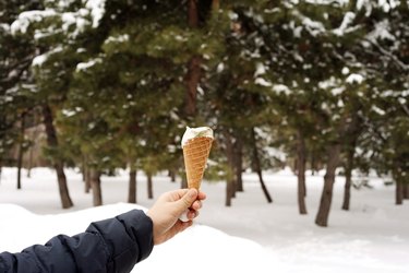 Hand holding ice cream cone during winter
