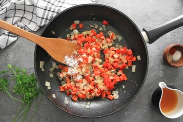 Toss onions and bell peppers in flour