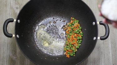 adding butter to wok
