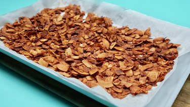 Baking coconut chips to make coconut bacon.