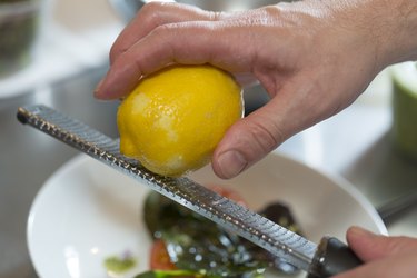 Cook Zesting the peel of a lemon on a microplane grater