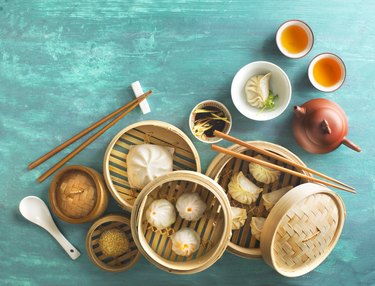 Chinese food dumpling and tea set on rustic table top.