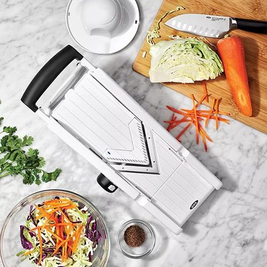 OXO V-blade slicer surrounded by ingredients, on a marble countertop