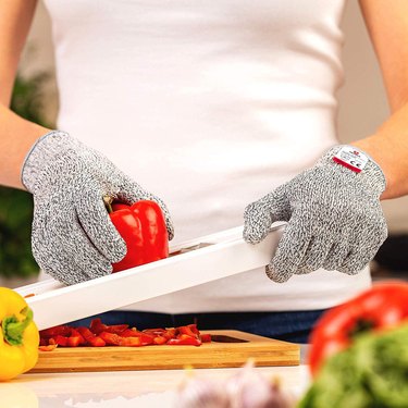 Woman using cut-resistant gloves with a mandoline slicer