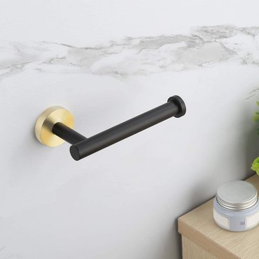 Gold and matte black wall-mounted toilet paper holder