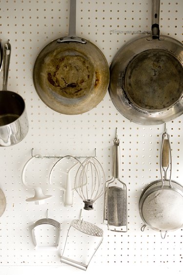 Cooking utensils hanging on white pegboard