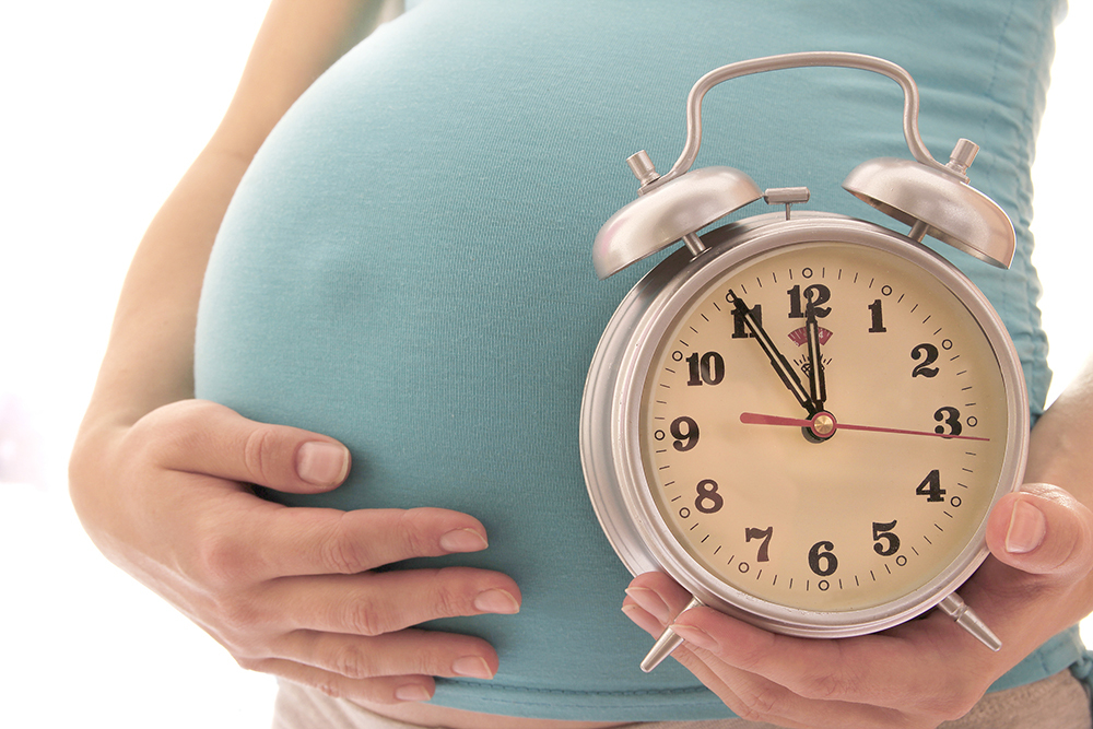 pregnant woman holding clock