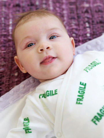 baby with "fragile" onesie
